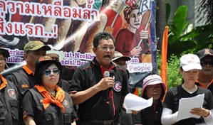 Man holding microphone at head of a worker rights rally