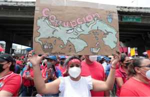 Cost-of-living protesters take to the streets in Panama, with a banner opposing corruption.